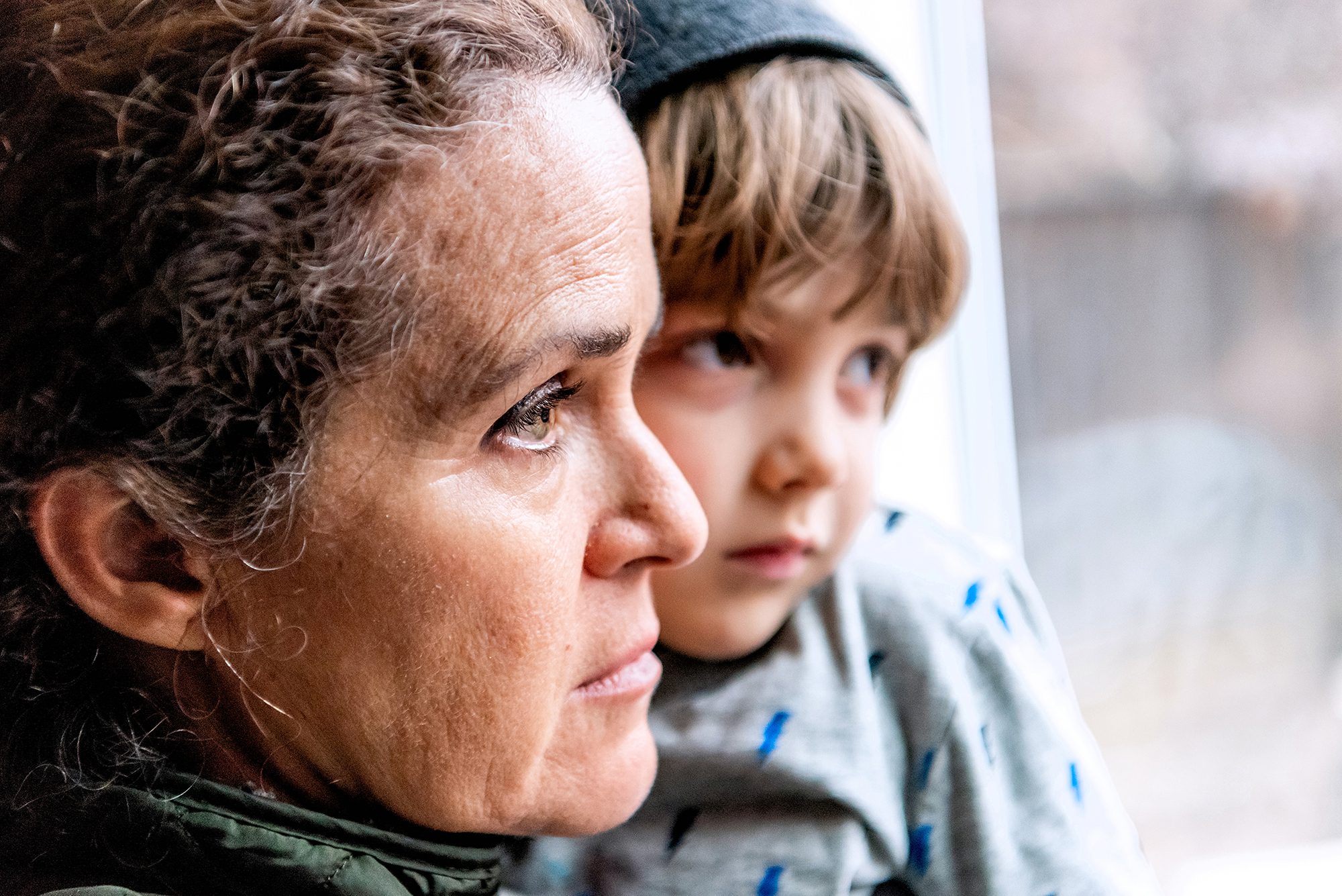 Mature woman posing with her son, very sad looking through window worried about loss of her job due Covid-19 pandemic DONATE new - Visionwest